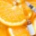 A syringe and a glass vial with a plain white label sit atop sliced oranges in a close-up overhead view, representing Vitamin C Brightening in San Antonio, TX