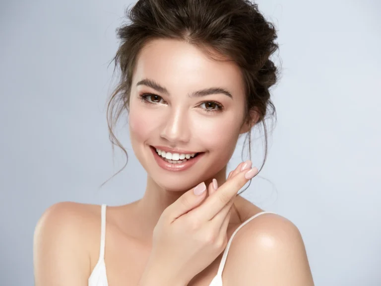 Smiling woman with clear, glowing skin showcasing healthy complexion and natural beauty after professional skincare treatment.