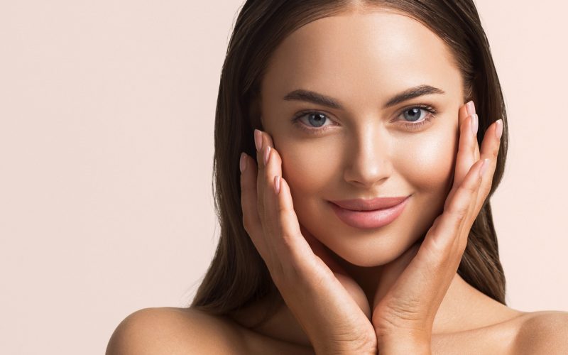 Beautiful woman face close up natural make up hand touching face beauty smile Beautiful woman face close up natural make up hand touching face beauty smile